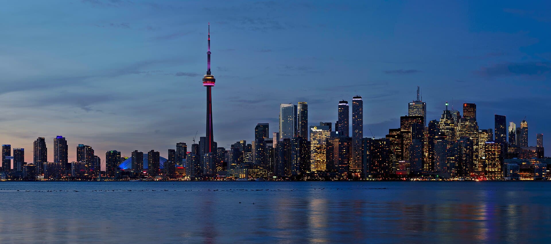 The Toronto skyline and CN Tower at dusk, seen across Lake Ontario